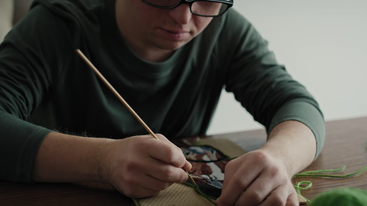 Close up of adult caucasian man with down syndrome making a craft.