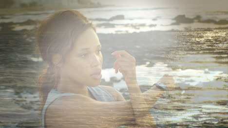 animation of african american woman exercising at beach over sea