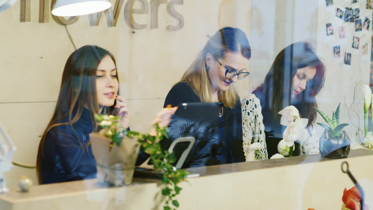 el personal de la floristería hace ramos de flores para la venta 1