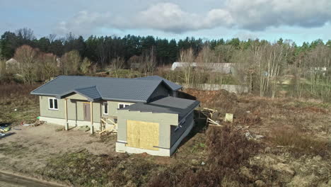 aerial drone rotating shot over newly-built wooden houses surrounded by very few houses on a sunny morning