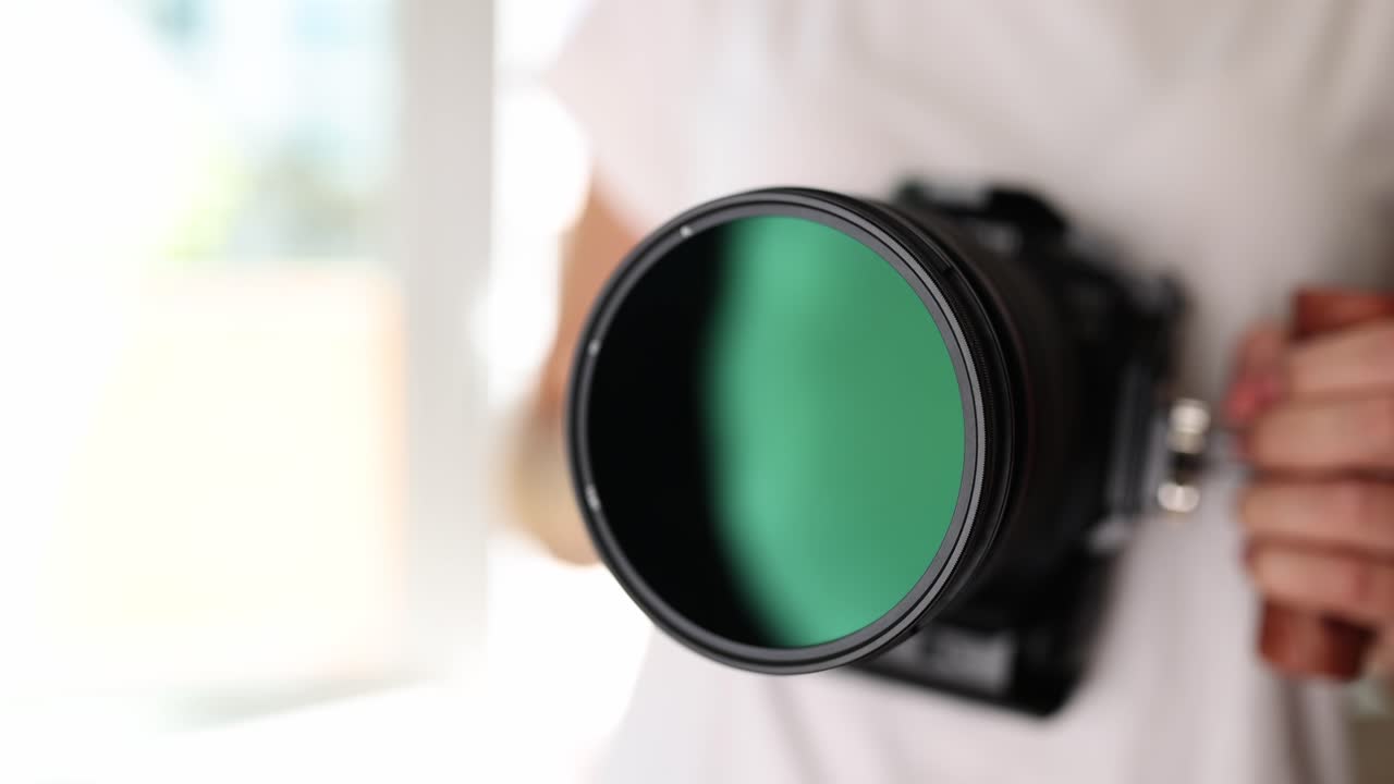 Close-up of a camera lens with a green filter