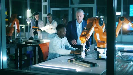 team of engineers are holding a research over a robotic device
