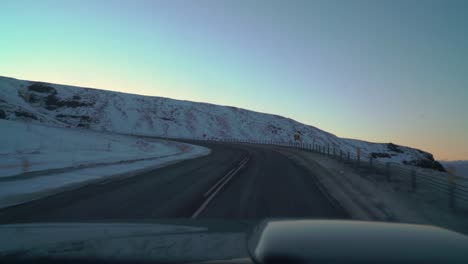 driving on icy roads in iceland in the winter towards the sunrise in february