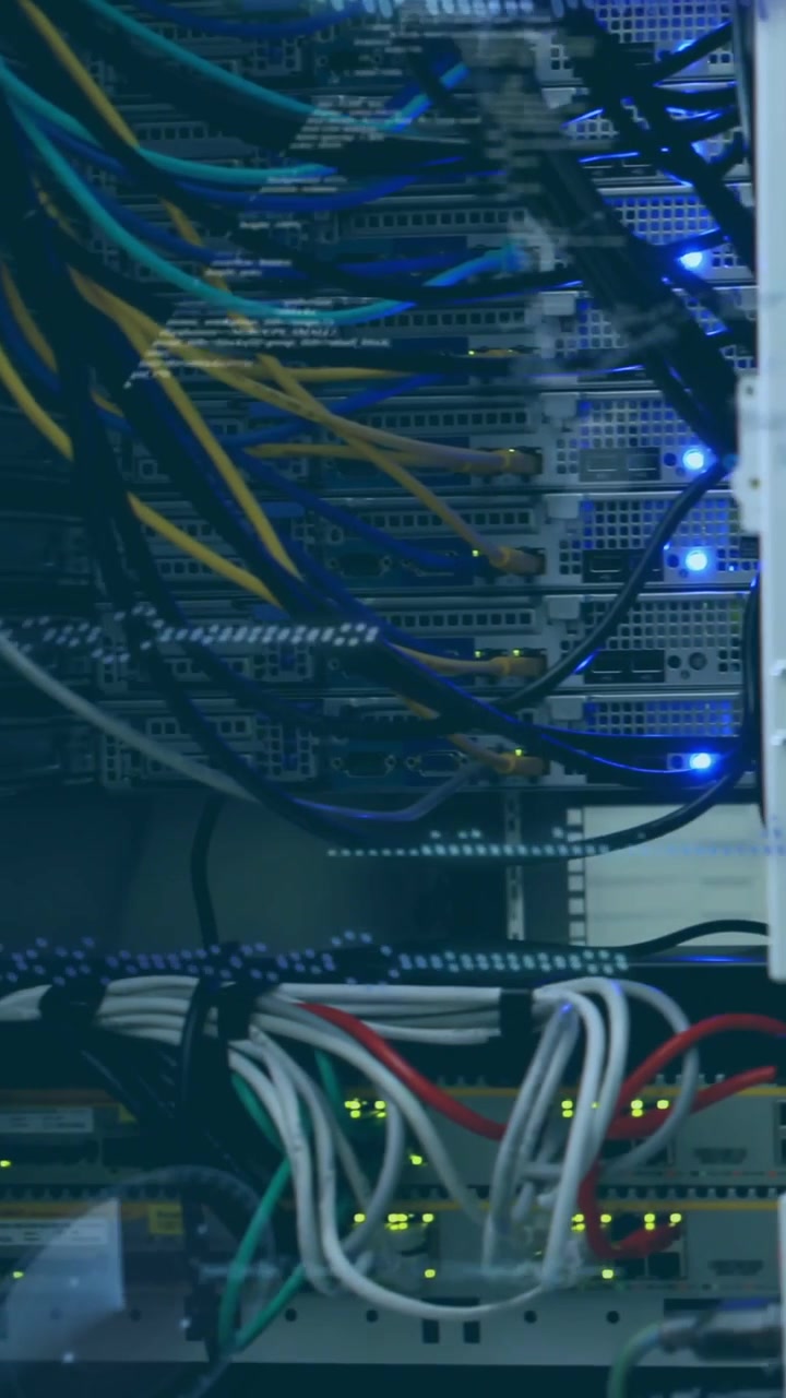 Video verticale: Telecamera che scorre su un rack di rete mostrando unità, cavi e un overlay LED che mappa il traffico.