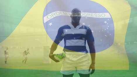 animation of brazilian flag waving over african american male rugby player holding a ball