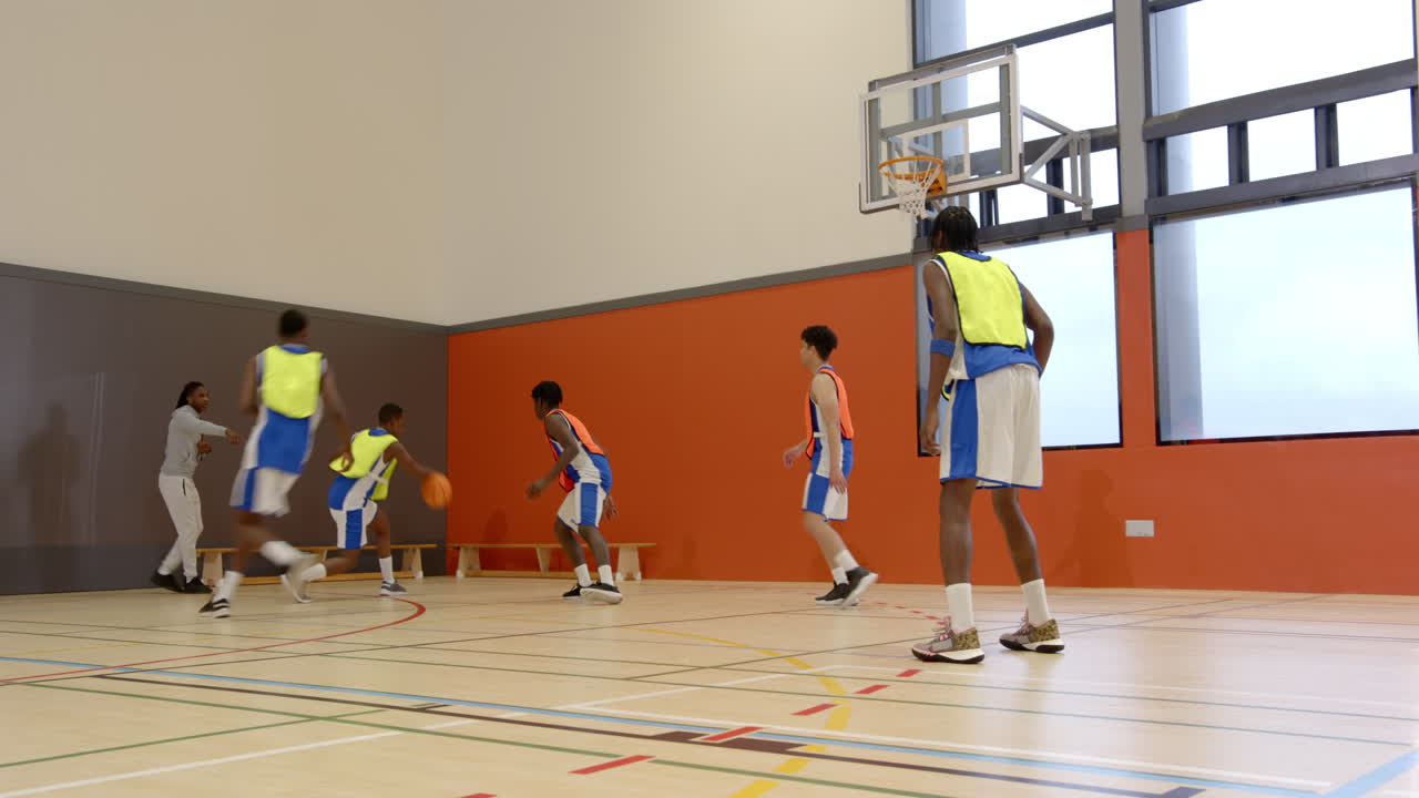 Basketbal spelen in schoolgymzaal, jongens oefenen spel- en teamwerkvaardigheden