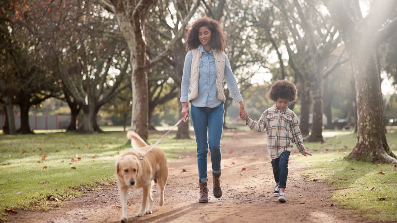 Mother and son walking with their dog in the park