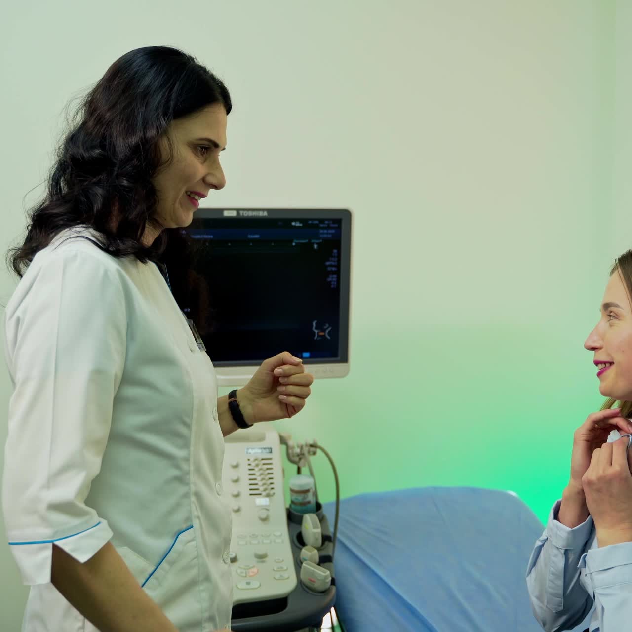 Woman patient visits doctor. Young female coming into the cabinet in the hospital. Professional doctor greets the patient in the modern clinic.