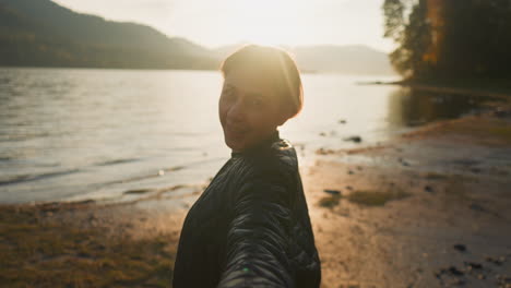 frau führt mann bei sonnenuntergang von hand. liebe zwischen jungen leuten und feiertage zusammen auf dem land. genießen sie einen positiven moment im leben und die schönheit der unberührten natur am abend