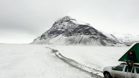 Beautiful-campervan-spot-with-a-completely-snow-covered-Iceland-with-a-mountain-peak-in-the-background