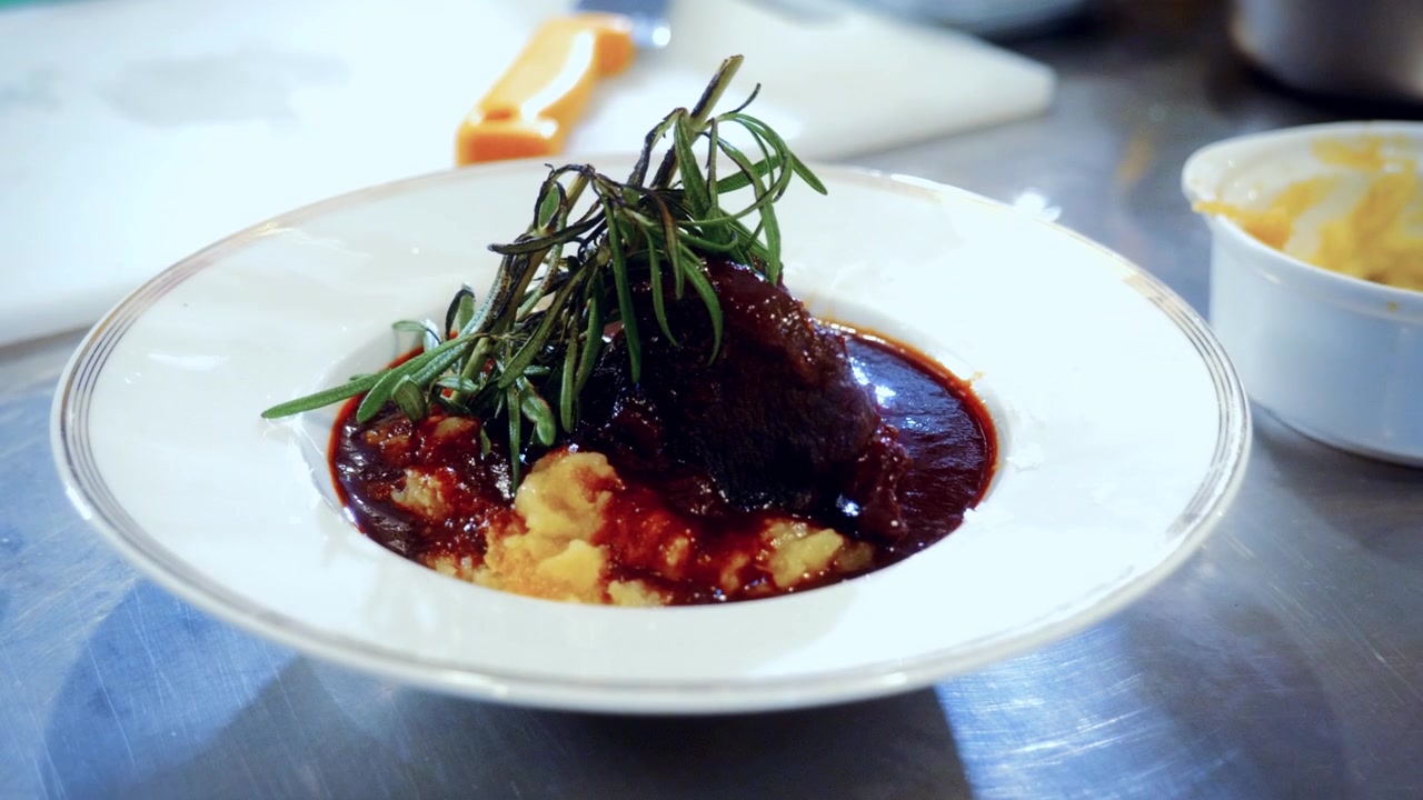 Authentischer Zubereitungsprozess eines italienischen Rindereintopfs mit Kartoffelpüree, genannt Spezzatino di Manzo, in einem traditionellen italienischen Restaurant.