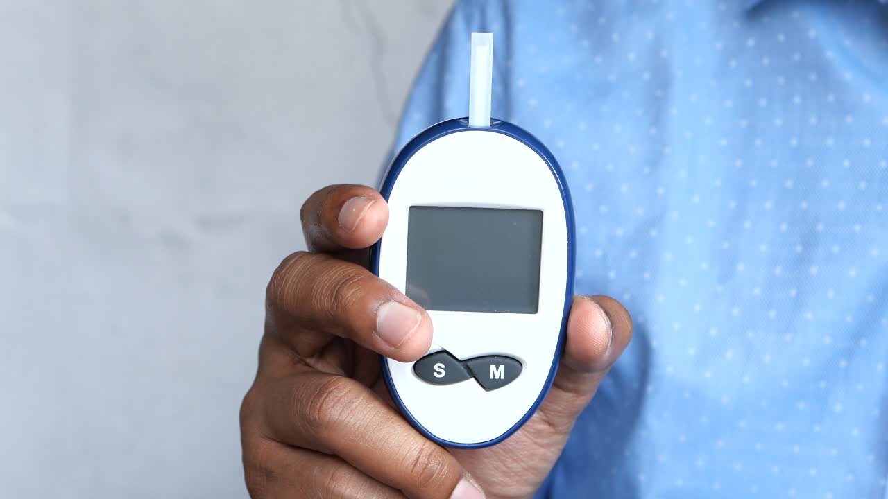 Person holding a blood glucose meter