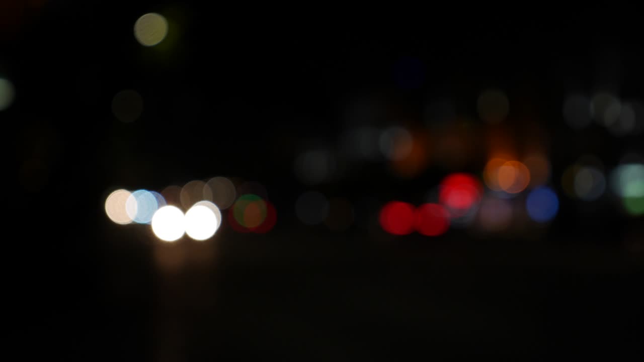 hermoso bokeh brillante en el fondo oscuro borroso por la noche. el redondo bokeh colorido brilla de las luces de los coches en la calle de la ciudad. fuera de foco con borroso. luces de la ciudad sin enfoque. bokeh de tráfico. concepto abstracto