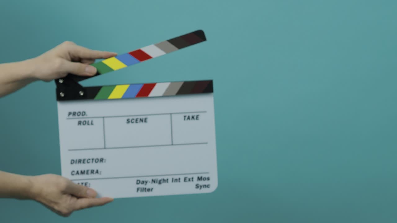 clapperboard golpeando. pizarra de película de película. cerrar la mano aplaudiendo pizarra de filmación vacía en fondo de color pantalla azul o verde. dentro y fuera de pizarra de películas cortando para producción de video. filmación o rodaje de películas.