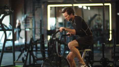 Hombre-Deportista-Ansioso-Entrenando-En-Bicicleta-De-Ejercicio-En-El-Gimnasio.-Hombre-En-Forma-Haciendo-Cardio-En-El-Club-Deportivo