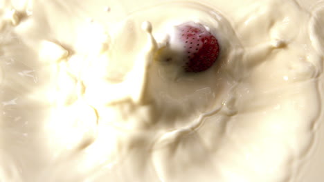 strawberry falling in glass of milk