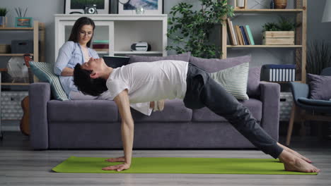 pareja practicando yoga en casa