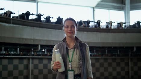 Smiling-livestock-manager-posing-in-dairy-production-facility-parlour-alone.