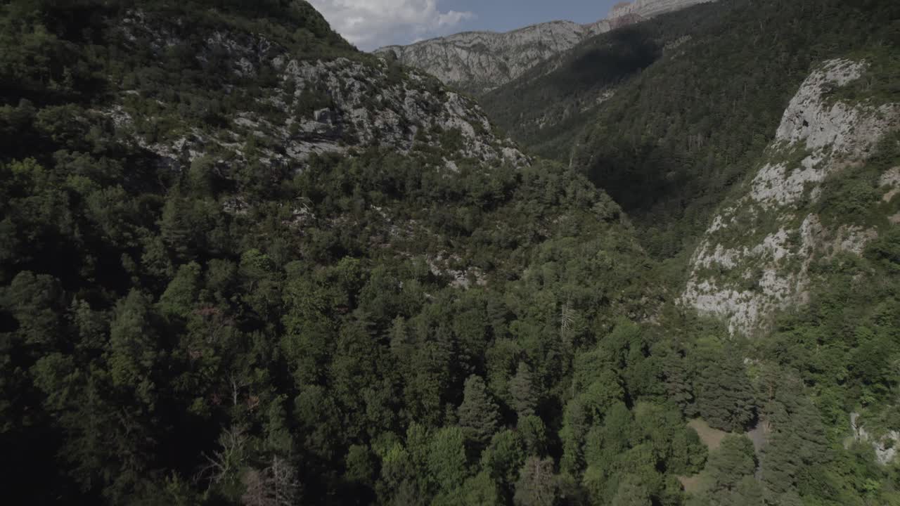 This drone video captures a stunning frontal descriptive shot over the lush green mountains of the Western Valleys Natural Park in Spain. A mesmerizing blend of natural beauty and tranquility.