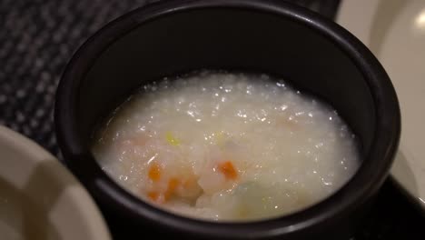 korean vegetable rice porridge mixing with spoon close-up