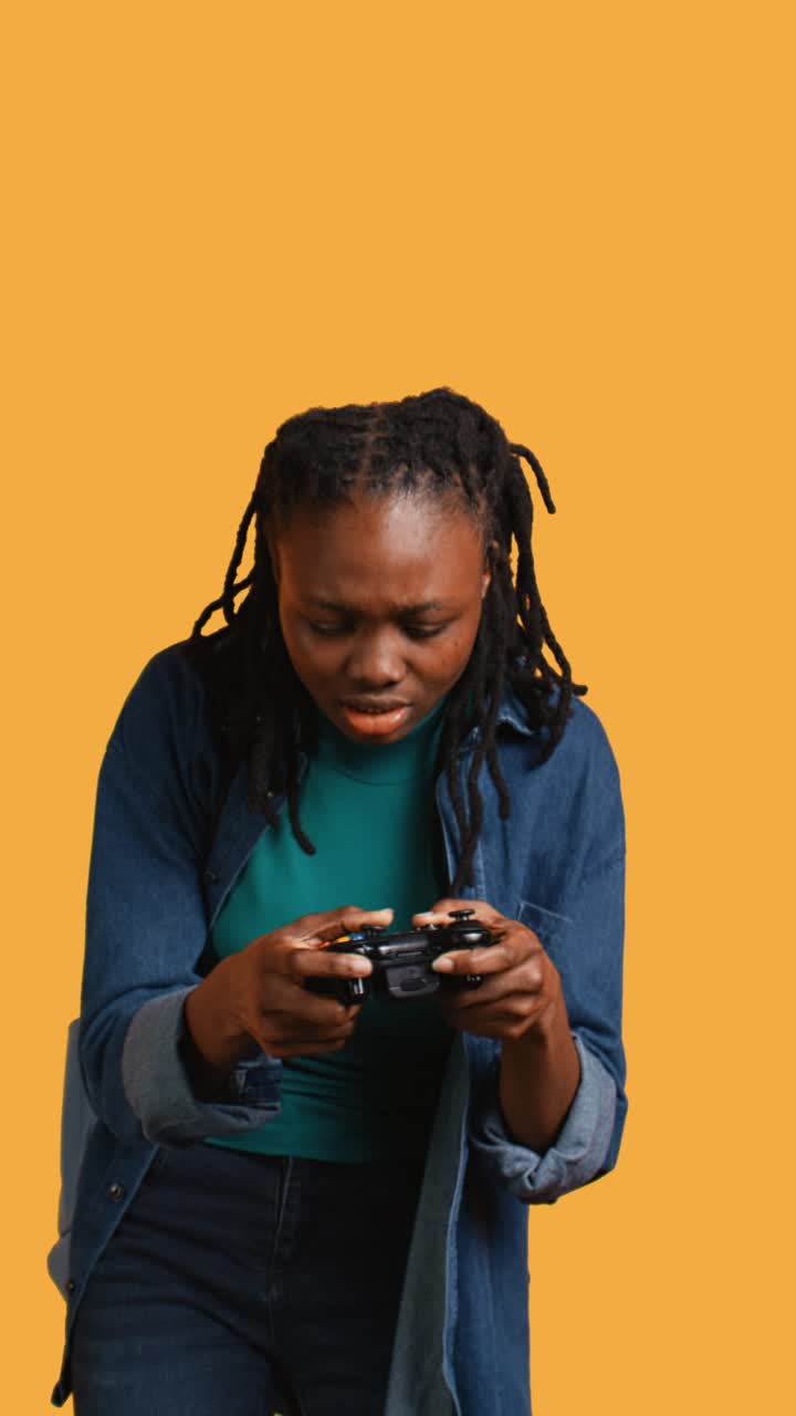 Young Black Woman Playing Video Game with Controller on Yellow Background