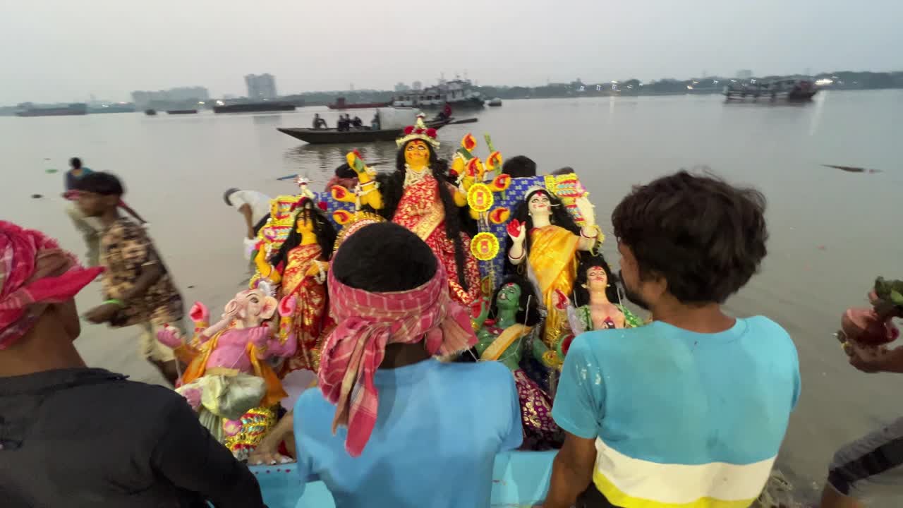 Front view of Durga Maa getting immersed into holy Ganga river during evening in Kolkata, India. Last day of Durga puja.