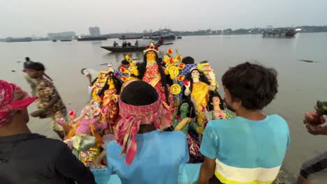 front view of durga maa getting immersed into holy ganga river during evening in kolkata, india. last day of durga puja.