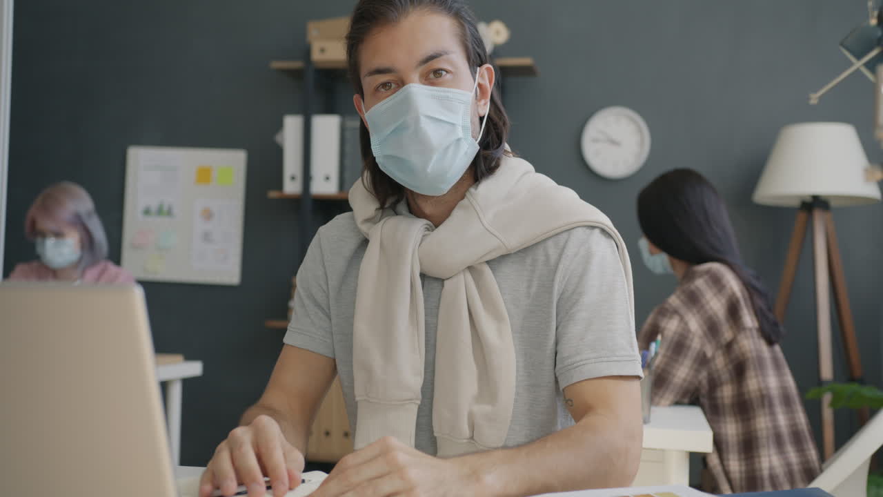 オフィス環境でマスクを着用している人々