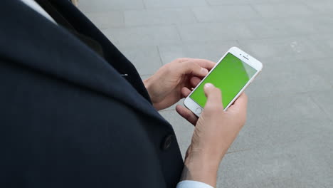 businessman browsing internet on phone at street. worker using mobile phone