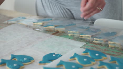 footage of a caucasian woman making and icing whale cookies