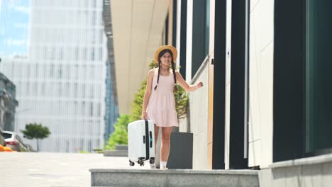 una mujer joven con una maleta caminando por la ciudad.