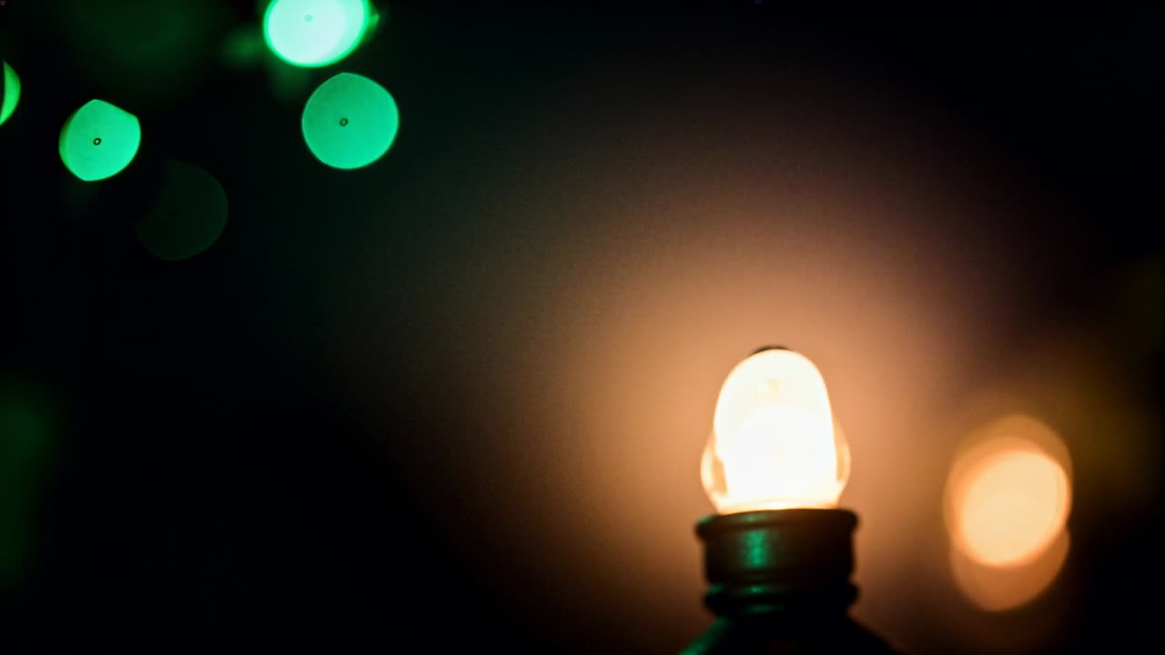 Messa a fuoco, obiettivo che sposta il bokeh a trifoglio per mettere a fuoco il portalampada ambra a destra su un tavolo in penombra, spazio per il testo