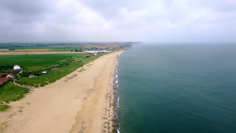 Aerial-shot-of-a-beautiful-seaside-coastal-town-and-farmland-in-Norfolk,-England