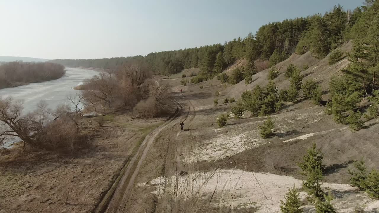 persona en bicicleta a lo largo de un sendero fluvial en un bosque