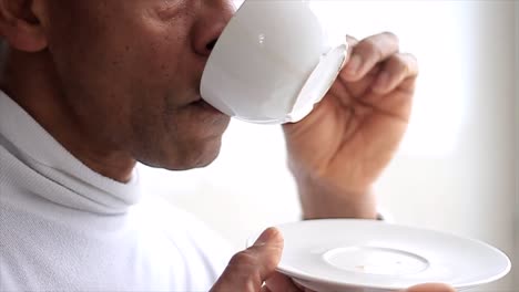 hombre bebiendo una taza de café caliente con fondo blanco almacen de metraje de video