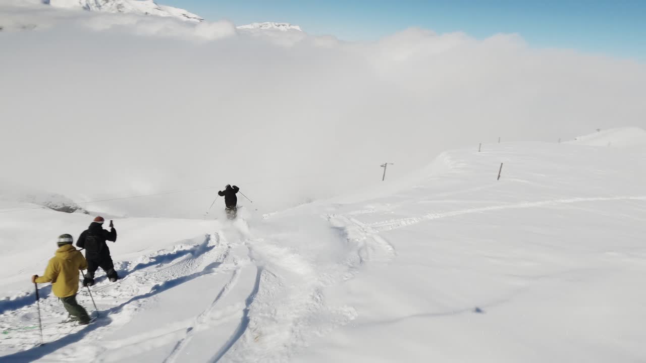 An exhilarating FPV drone shot capturing a skier carving through deep powder snow on a bright winter day. The dynamic perspective highlights the skier's movement and the untouched snowy terrain.