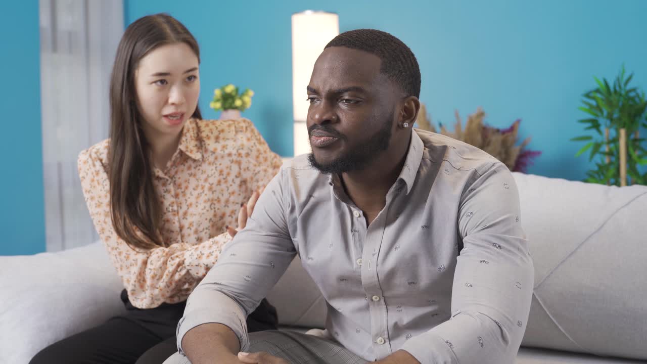 Asian woman tries to calm her African partner about her anger.