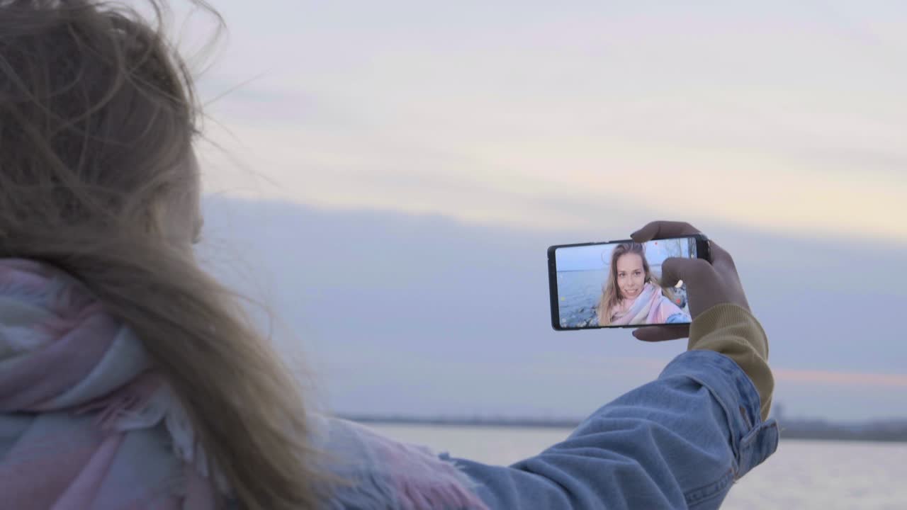 cámara de teléfono haciendo fotos de la cara de la chica en la playa