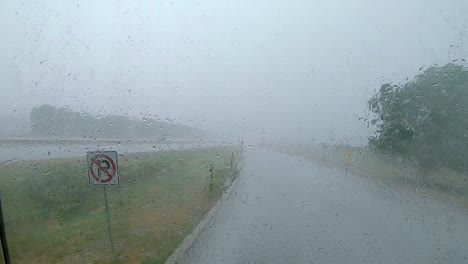 Lluvia-Torrencial-Golpeando-Un-Parabrisas-Grande-Mientras-El-Vehículo-Está-Esperando-La-Tormenta-De-Lluvia-En-Un-área-De-Descanso-A-Lo-Largo-De-La-Interestatal