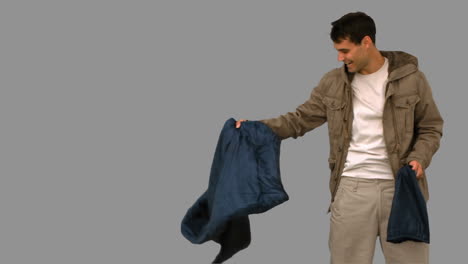 man rolling out his sleeping bag on grey screen