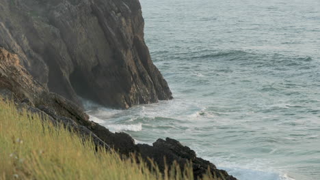 ocean waves crashing on rocky coast and cliffs of sao pedro de moel in leiria, portugal