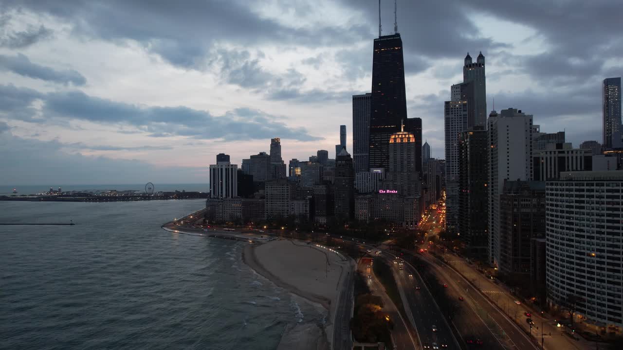 Drone che scende verso Chicago all'alba, mostrando la città, autobus, auto e il Lago Michigan.