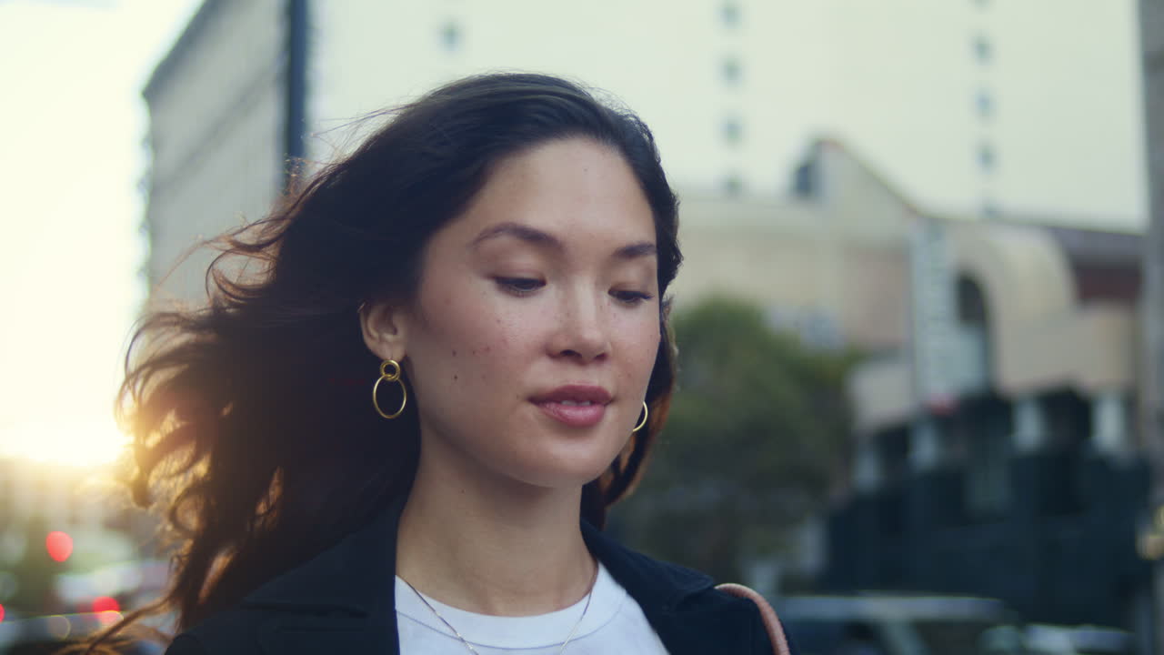 una mujer atractiva camina sola por megapolis en primer plano. una mujer asiática relajada va a la calle.