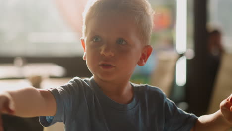 Little-boy-plays-with-empty-glass-as-listening-tool-in-room