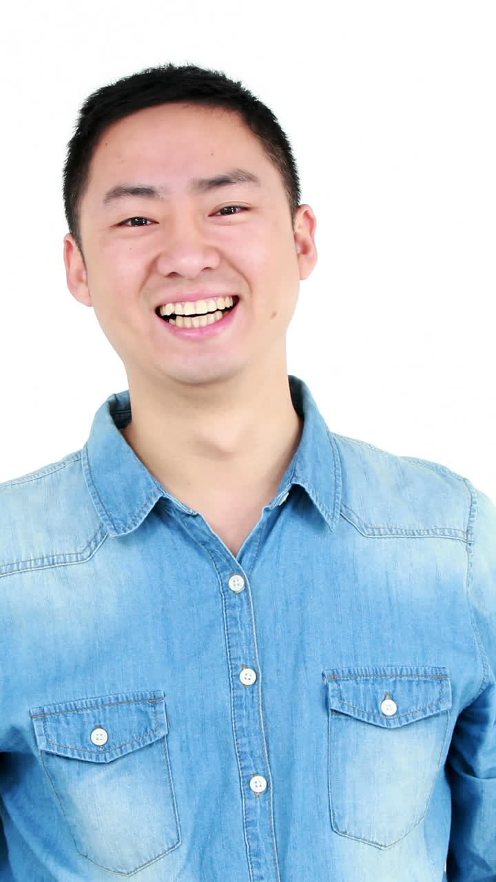 행복한 아시아인 남자가 카메라에 엄지손가락을 보여줍니다.