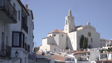 white church in coast town, birds flying at the background, clear sky, costa brava, spain, static shot