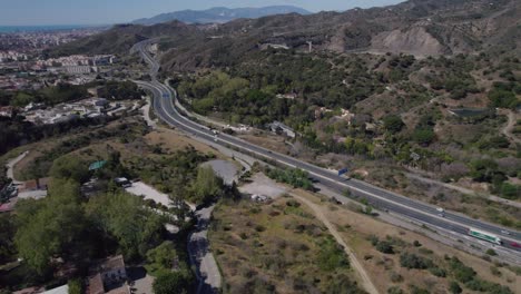 a highway running beside houses spread out through the forest