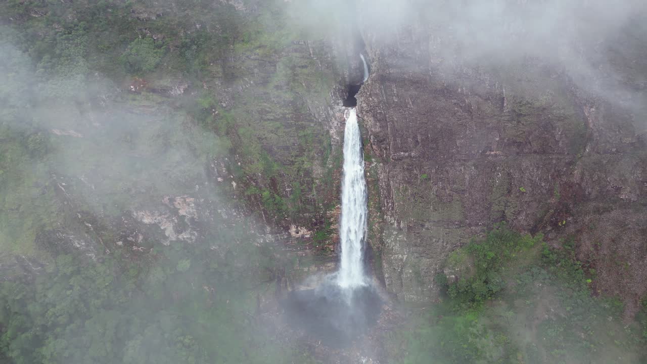 Dramatic tall Casca D'anta waterfall as aerial retreats through clouds