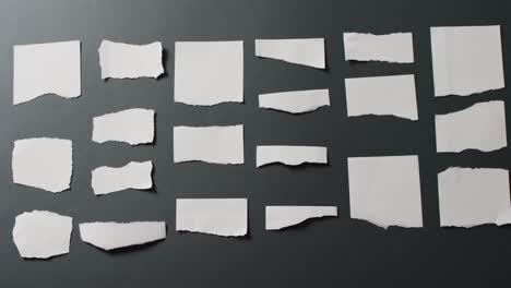 Video-of-close-up-of-multiple-torn-piece-of-white-paper-with-copy-space-on-black-background