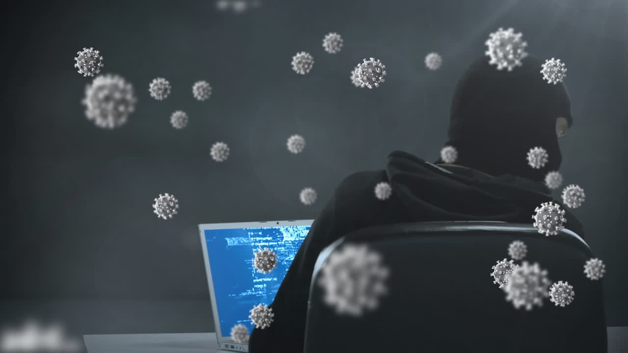 animación de las células macro covid19 sobre un hombre que lleva una balaclava, usando una computadora portátil